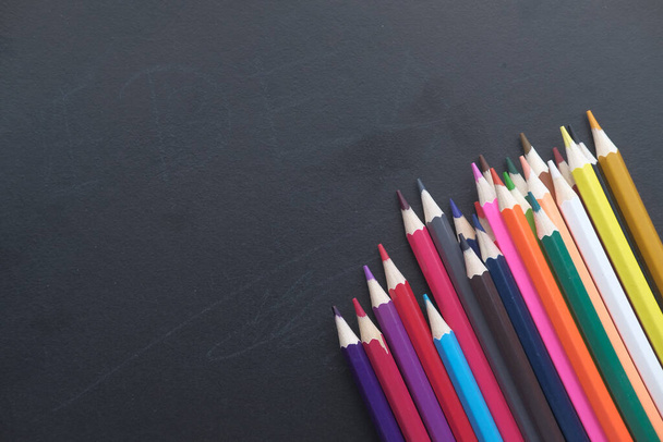 close up of colorful pencils on blackboard  - Zdjęcie, obraz