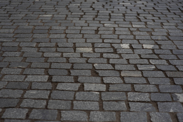 old European courtyard, paved with gray cobblestones. Pavers texture. A perspective view of the monotonous gray brick stone pavement on the ground for Street Road. Sidewalk, driveway, pavers - Фото, зображення