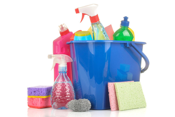 Diverse flessen met reinigingsmiddelen en reinigingsmiddelen in een blauwe emmer op een witte geïsoleerde achtergrond. - Foto, afbeelding