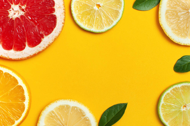 Composizione flat lay con fette di limone fresco arancio pompelmo tiglio foglie verdi su sfondo giallo vista dall'alto copia spazio. Citrus Juice Concept, Vitamina C, Frutta. Sfondo estivo creativo
. - Foto, immagini