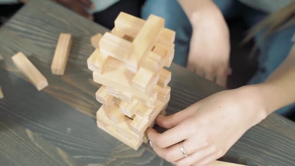 Close up hands of multinational friends playing block removal game. - Video