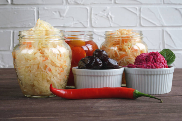 Fermented foods. Sauerkraut, salted tomatoes, pickled plums and spicy horseradish on a white background. Vegetarian food - Photo, Image