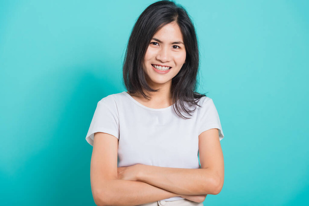 Portrait Asian beautiful happy young woman smile white teeth wear white t-shirt standing crossed arms, on a blue background with copy space - Fotoğraf, Görsel