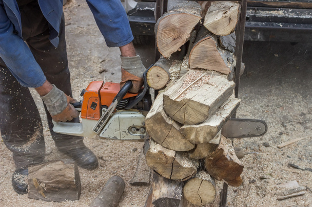 snijden stapel hout met een kettingzaag - Foto, afbeelding