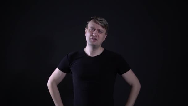 Dissatisfied man hands on waist, black background - Video