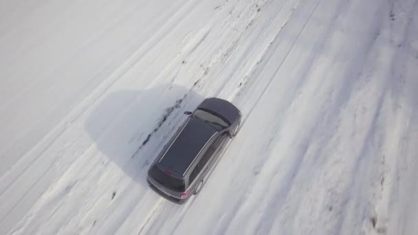  Οικογενειακό αυτοκίνητο οδήγηση σε ένα χωματόδρομο στο χιόνι καλύπτονται χειμώνα πεδίο. - Πλάνα, βίντεο