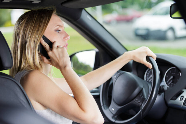 woman talking on cellphone while driving - Zdjęcie, obraz