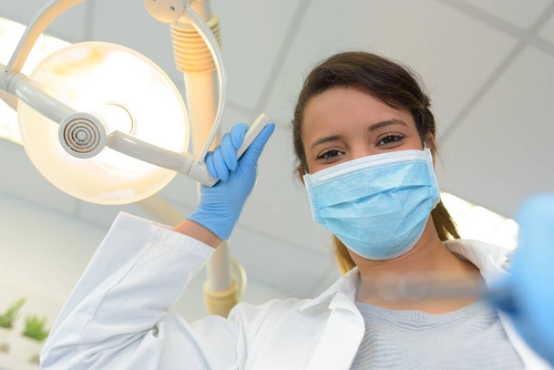 dentist adjusting the lamp - Фото, изображение