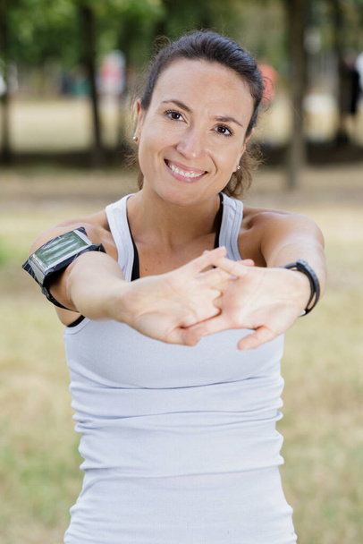 sporty woman enjoying stretching arms and body - Foto, imagen