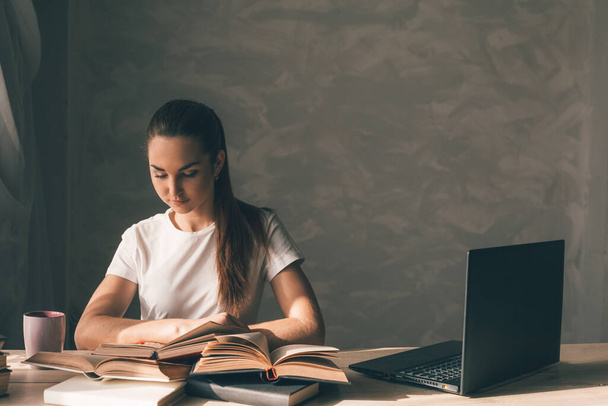 girl is preparing for the exam and reads a book - Photo, Image