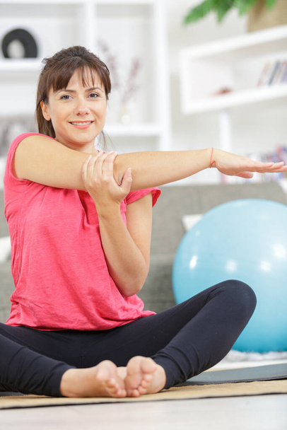 woman stretching arms at home - Foto, Imagen