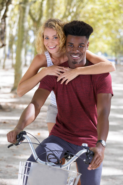 portrait of a mixed couple on a bicycle outdoors - Fotografie, Obrázek