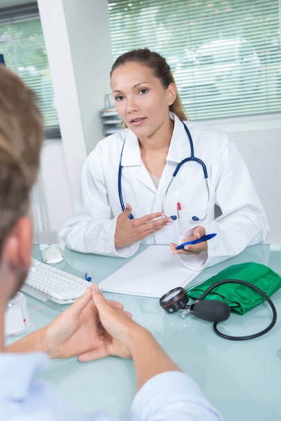 attractive young female doctor looking at a patients history - Photo, image