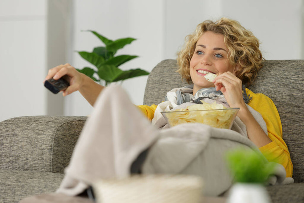 a woman eating a bowl of chips - Zdjęcie, obraz