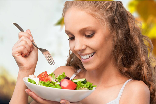 young woman eating salad in the kitchen - Photo, Image