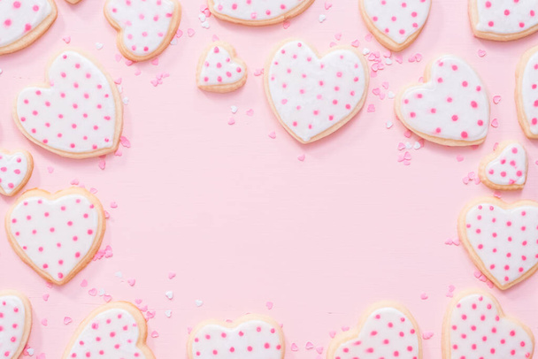 Плоский лежал. Сахарное печенье в форме сердца украшено королевской глазурью на День Святого Валентина на розовом фоне
. - Фото, изображение