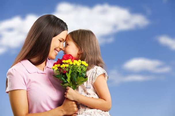 happy mother and daughter with flowers - Фото, изображение