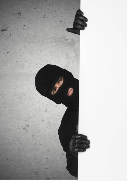 man with black mask with blank banner  - Фото, зображення