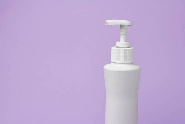 Wzór białej butelki z dozownikiem na fioletowym tle. Opakowanie kosmetyków. Kopiuj miejsce na reklamę produktu kosmetycznego - Zdjęcie, obraz