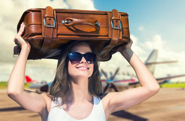 Travelling woman with suitcase on blurred airport background - Foto, Imagem
