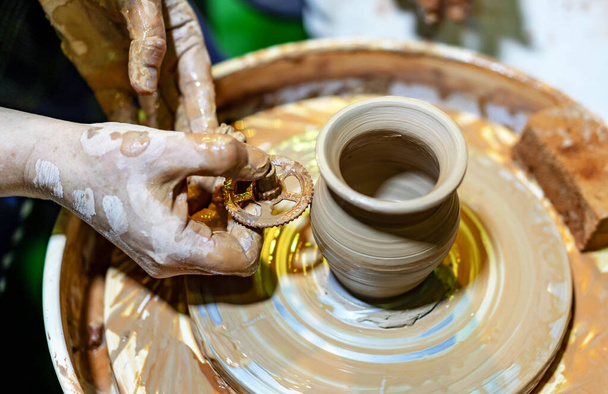 Alfarero profesional hace una olla en una rueda de cerámica. Las manos de un alfarero
. - Foto, imagen