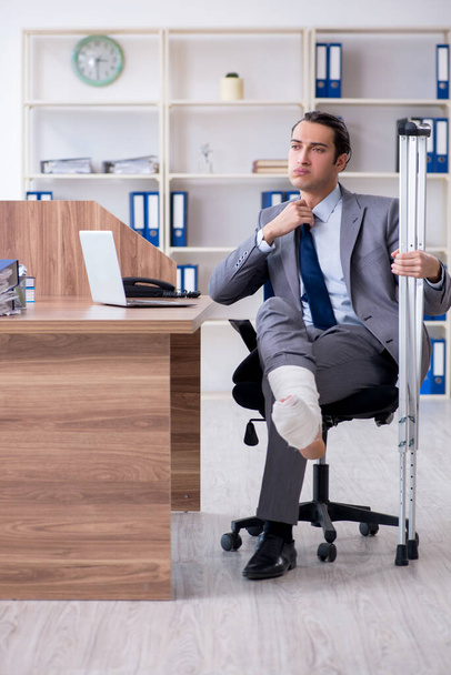 Leg injured male employee in the office - Foto, imagen