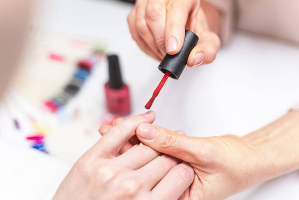 Close up of manicure master that polishing nails - Foto, afbeelding