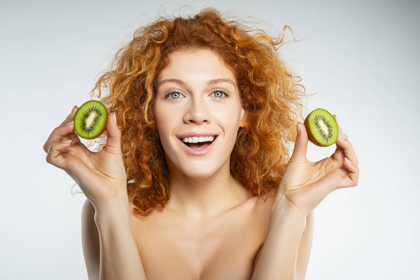 Close up of pretty girl that holding kiwi - Foto, afbeelding