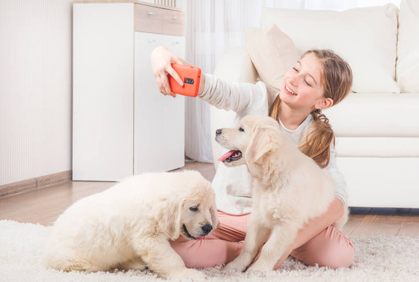 Girl taking selfie with retriever puppies - Foto, immagini