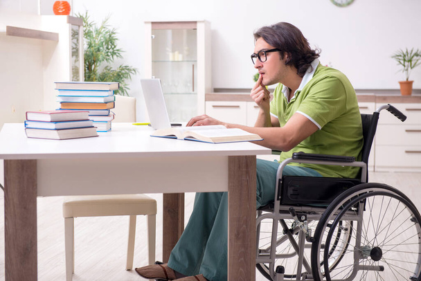 Młody student na wózku inwalidzkim w domu - Zdjęcie, obraz
