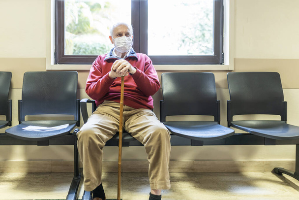 anciano sentado en el consultorio de un médico en un hospital con respirador
 - Foto, Imagen
