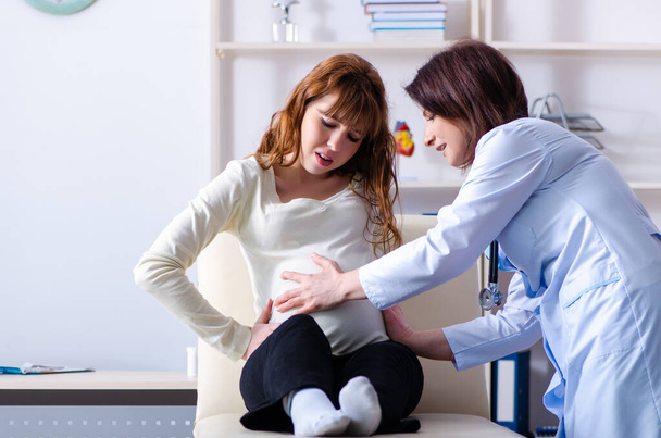 mujer embarazada joven que visita médico experimentado ginecólogo - Foto, imagen