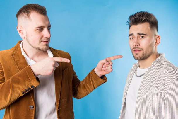 portrét dvou mladých mužů, jak spolu mluví, na modrém pozadí  - Fotografie, Obrázek