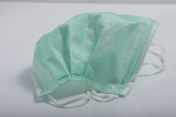 Beyaz arkaplanda yeşil tıbbi maske izole edildi - Fotoğraf, Görsel