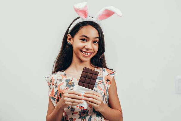 Portrait of happy little girl celebrating easter eating chocolate - Fotoğraf, Görsel