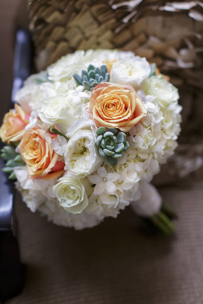 Orangefarbene und weiße Rosen, Hortensien und Kakteen Hochzeitsstrauß von Blumen auf einem Stuhl - Foto, Bild