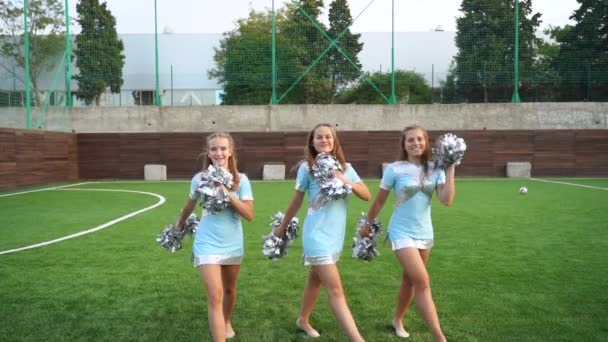 Chicas jóvenes en porrista en uniforme con pompones apoyo equipo deportivo en la universidad
 - Metraje, vídeo