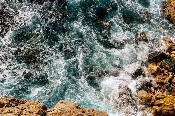 Zbliżenie na Morze Śródziemne turkusowa woda i potężne fale uderzające o skały na wybrzeżu - Zdjęcie, obraz