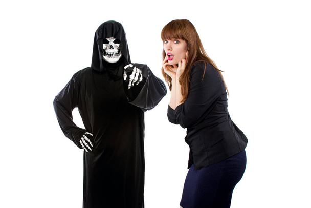 Scared businesswoman paranoid of catching a deadly disease represented by the grim reaper.  She is frightened of contracting a pandemic illness such as coronavirus - Zdjęcie, obraz