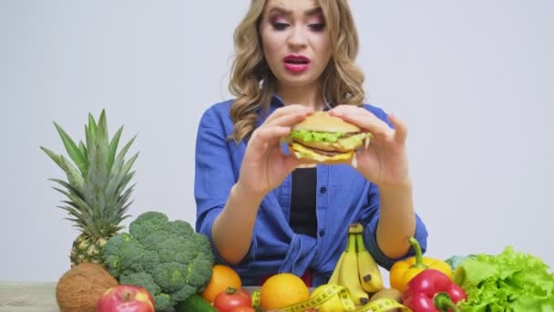 Έννοια της υγιεινής διατροφής, μια γυναίκα που κατέχει ένα burger επιβλαβές - Πλάνα, βίντεο