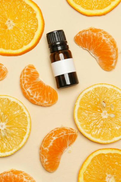 Aceite esencial de cítricos, naranjas, mandarinas y rodajas de limón con botella de aceite
 - Foto, imagen