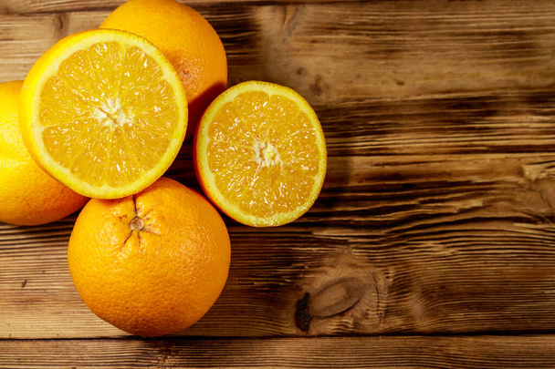 Πορτοκάλια φρέσκα σε ξύλινο τραπέζι - Φωτογραφία, εικόνα