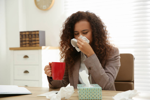 Sick African-American woman at workplace. Influenza virus - Fotó, kép