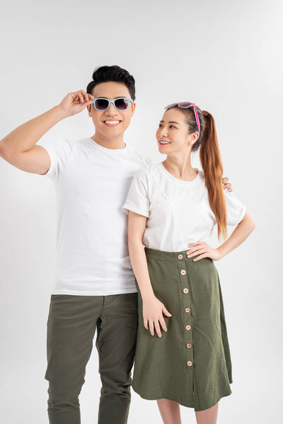 Surprised young couple looking at camera. Front view of excited young man and woman standing together and looking at camera on white background. Emotion concept - Photo, image