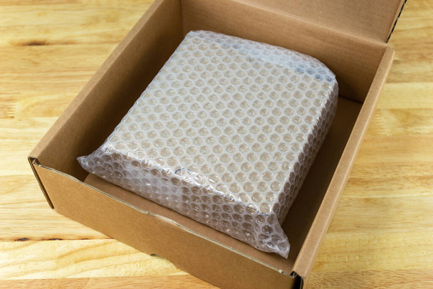 Bulles recouvrant la boîte par un emballage à bulles pour le produit de protection fissuré ou l'assurance Pendant le transit  - Photo, image