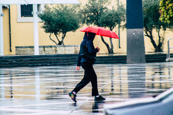 Limassol Cyprus March 12, 2020 View of unidentified people walking in the streets of Limassol during a raining day - Фото, зображення