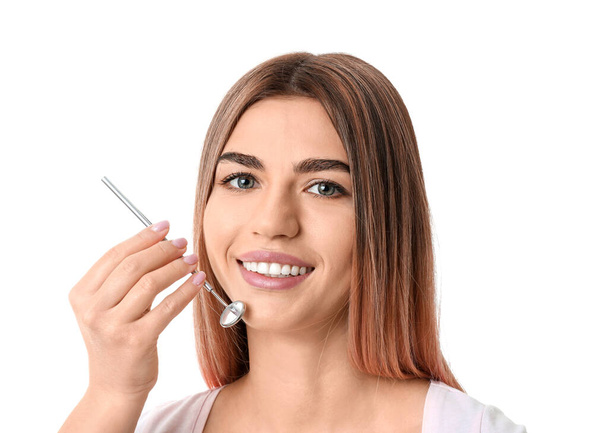Beautiful young woman with dental mirror on white background - Zdjęcie, obraz
