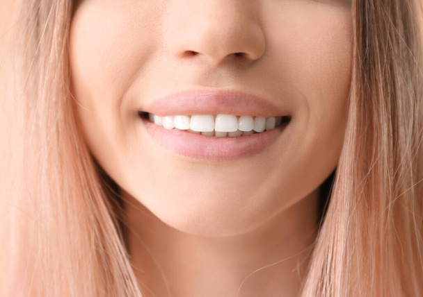 Mladá žena s zdravé zuby na barvu pozadí, closeup - Fotografie, Obrázek