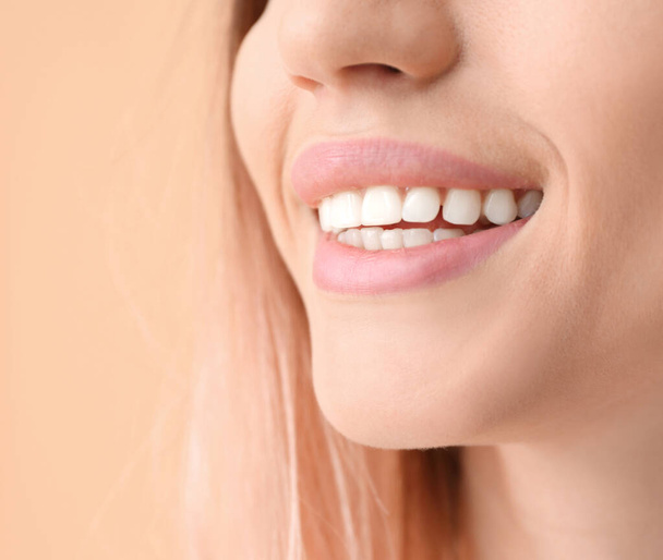 Young woman with healthy teeth on color background, closeup - Фото, зображення