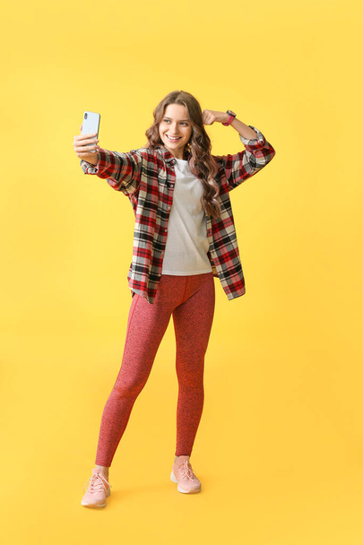 Mujer joven tomando selfie sobre fondo de color - Foto, Imagen